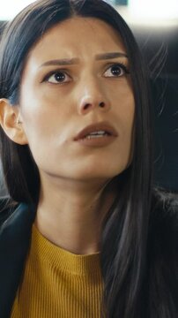 Vertical Screen: Professional woman working on a laptop in an office receives a termination note. Her shocked and concerned reaction captures the emotions of unexpected job loss. Workplace dismissal