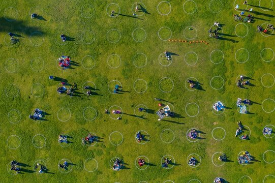 Social distancing in a park in Covid19. People enjoy a sunny day, practicing safe social distancing in marked circles.  Mission Dolores Park, San Francisco, California, USA