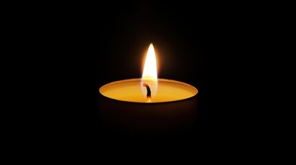 A single burning candle casting a warm glow in complete darkness