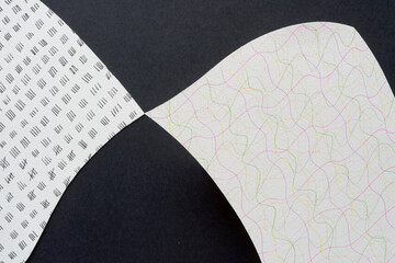 two abstract cut paper shapes with pointy tip and decorative patterns on black