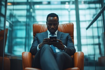 Businessman relaxing in modern lounge while checking smartphone during work hours in corporate office environment