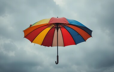 An umbrella with vibrant colors floating in a grey sky, colorful umbrella floating in a grey sky

