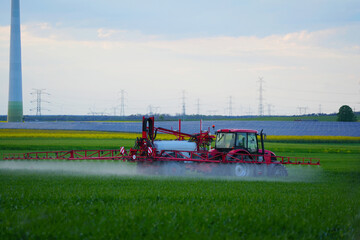 Tractor water green field with fertilizer.