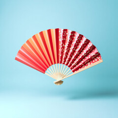 red and hand fan with polka dots on blue background