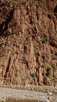 Scenic mountain gorge with steep rocky cliffs under a clear blue sky in Todra Gorge, Morocco