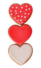 Three gingerbread cookies in the shape of hearts in red, white and red polka dots isolated.