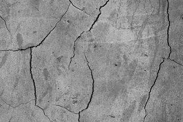 A high resolution old concrete cement with cracks and natural destruction from time and weather conditions. Non-color, monochrome black and white photo.