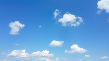 Fototapeta premium vast blue sky with puffy white clouds scattered across it, serene atmosphere, open space