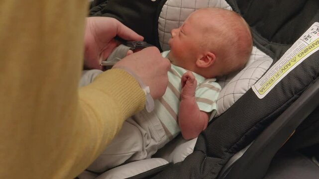 New Born Baby Getting Buckled into Carseat for the First Time
