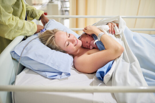 Healthcare, woman and skin with baby for bonding, maternal security and hug for wellbeing after birth. Hospital, mother and newborn infant in maternity ward with doctor, labor and loving relationship