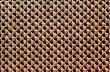 Raised diamond-shaped facets repeating pattern brown abstract textured background