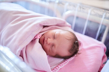 Newborn, baby and sleeping with blanket at hospital for childbirth, delivery or bassinet. Infant, swaddle or wrap with child or kid asleep with fabric, sheets or bed for rest, dream or nap in bedroom