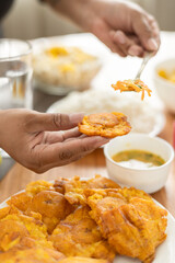 Crispy fried patacones served with spicy hot sauce, a delicious and traditional breakfast dish, perfect for savory food and Latin cuisine.