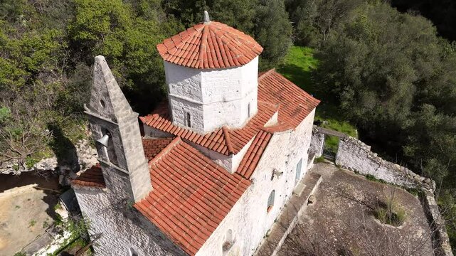 Breathtaking aerial drone footage of the historic Moni Sotiros Monastery near Kardamyli, Greece, surrounded by stunning Mediterranean landscapes. 
