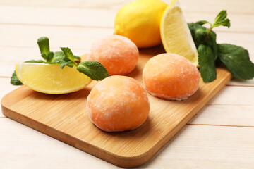 Delicious mochi, lemons and mint on wooden table, closeup