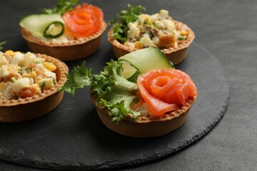 Tartlets with delicious fillings on black table, closeup