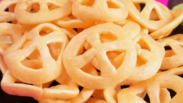 Acercamiento a chicharrines, en forma de rueda, un bocadillo mexicano frito. Con salsa y limones