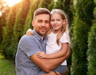 Fototapeta premium Padre e hija abrazados en el jardín, día del padre.