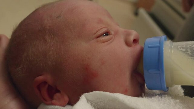 Closeup of a Newborn Baby Drinking a Bottle of Milk