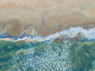 Birds eye view of the surf rolling on the beach at sunrise. Taken by drone from 200 ft. the location is on the east coast of North Carolina.