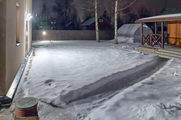 A path in the snow between the house and the veranda