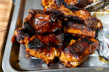 Savory grilled ribs served on a metal tray in a backyard setting