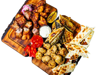 Grilled meat platter with sides served on a wooden board