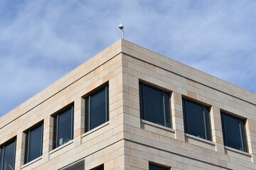 Corner of modern government building, 360 security camera mounted on top.