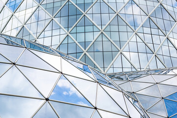 Blue sky and clouds reflecting in windows of modern office building