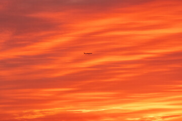Aerial photo of another aircraft Silhouette against the Sunset sky clouds as it take off 