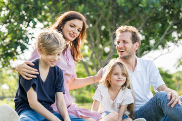 Fototapeta premium Happy family parent children having picnic outdoor activity. Enjoy happiness moment summer playing together including father mother son and daughter relaxing in the morning sunrise.