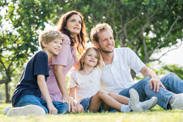 Fototapeta premium Happy family parent children having picnic outdoor activity. Enjoy happiness moment summer playing together including father mother son and daughter relaxing in the morning sunrise.