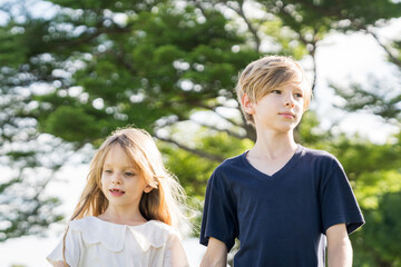 Obraz premium Brother and sister playing together at the park in the morning sunrise