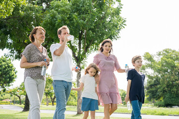 Fototapeta premium Happy family parent children having picnic outdoor activity. Enjoy happiness moment summer playing together including father mother son and daughter relaxing in the morning sunrise.