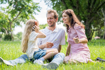Fototapeta premium Happy family parent children having picnic outdoor activity. Enjoy happiness moment summer playing together including father mother son and daughter relaxing in the morning sunrise.