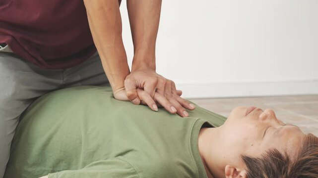 A woman performs chest compressions, administering CPR to an unconscious young man, demonstrating life-saving skills, emergency response, first aid, and medical assistance in a critical situation