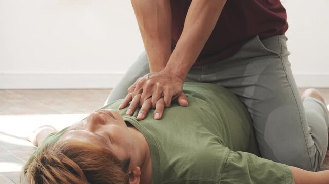 A woman performs chest compressions, administering CPR to an unconscious young man, demonstrating life-saving skills, emergency response, first aid, and medical assistance in a critical situation