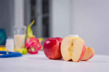 A supplement bottle and a fresh apple placed on the table, symbolizing health and nutrition, representing dietary choices, wellness, and natural or medical supplementation for a balanced lifestyle