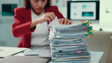Exhausted office employee overwhelmed by massive paperwork stack, slumping at workstation with computer and business charts surrounding workspace - Powered by Adobe