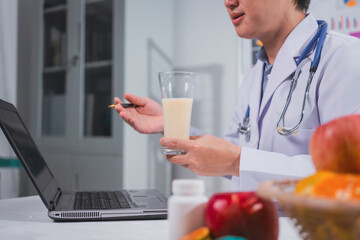 A male nutritionist works at his desk, discussing the benefits of eating fruit. He analyzes diets...