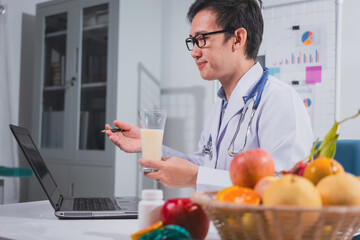 A male nutritionist works at his desk, discussing the benefits of eating fruit. He analyzes diets...