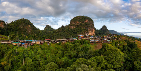 Obraz premium Amazing aerial view of the sunrise over a small mountain village landscape, mountains in the background, a ravine in the foreground with a sea of ​​mist, a peaceful atmosphere and natural beauty.