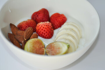 yogurt with fruit topping or strawberry, almond with fig and banana in natural yogurt