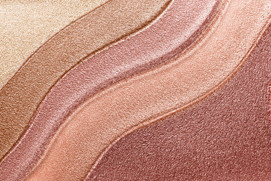Makeup texture background. Bronze shimmer metallic lipstick or liquid eye shadow palette smeared