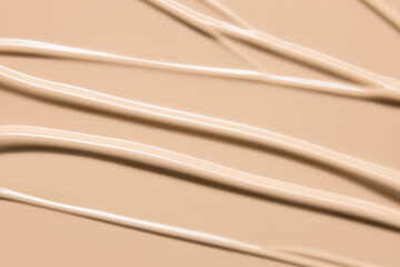 Makeup foundation cream texture background. Beige concealer, BB cream smeared