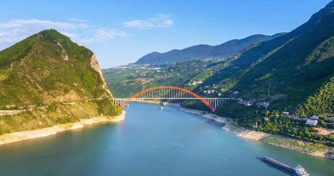 aerial time lapse video of the Wushan Yangtze river bridge and inland river vessels sailing, Wushan county, Chongqing city, China.