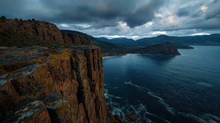 Dramatic coastal landscape showcasing rugged cliffs under a moody sky at dusk