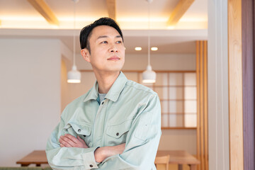 腕組みをする作業着を着た男性