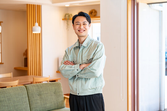 腕組みをする作業着を着た男性
