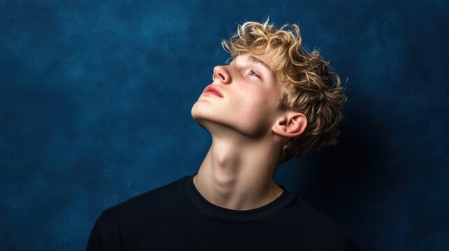Young Man with Blonde Curly Hair Looks Upward